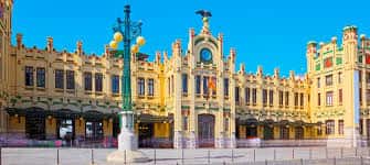 Vista panorámica de la fachada principal de la Estación del Norte en Valencia bajo un cielo azul despejado