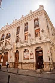 Vista lateral de la fachada del Teatro Talía mostrando su entrada principal y detalles arquitectónicos bajo luz diurna