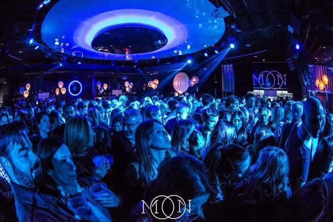 Público disfrutando de un evento nocturno en Sala Moon con iluminación azul y ambiente festivo