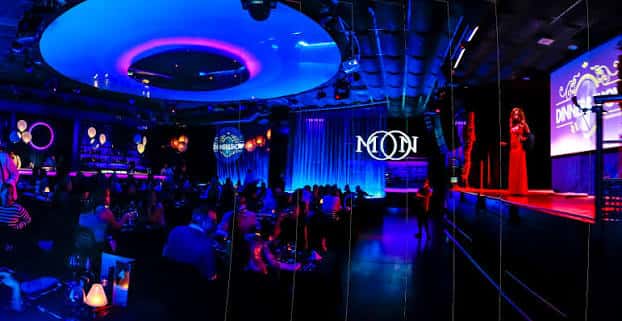 Interior de Sala Moon Valencia con escenario iluminado y público en mesas durante un evento