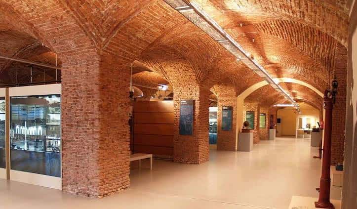 Interior del museo con bóvedas de ladrillo y salas de exposición