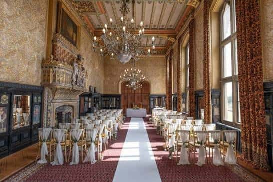 Salón interior del Carlton Towers decorado para una boda con sillas blancas y alfombra roja