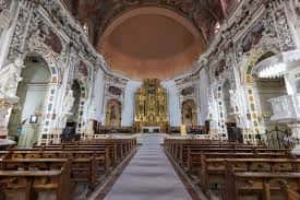 Nave central de la iglesia con bancos y cúpula