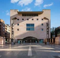Fachada exterior del edificio bajo cielo azul, mostrando su diseño arquitectónico moderno