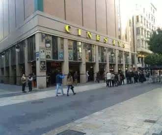 Fachada de Cines Lys con cartelera de películas y gente en la acera