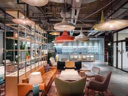 Área de lounge moderna con iluminación industrial y mobiliario acogedor