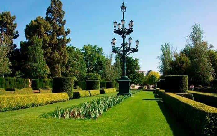 Paseo central del jardín con farola ornamental y césped bien cuidado