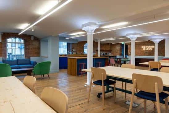 Sala de reuniones con mesas y sillas en un espacio amplio