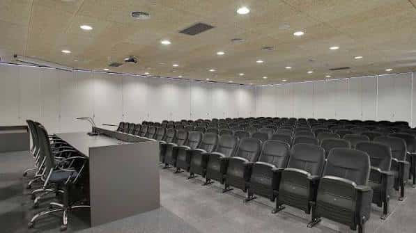 Sala de conferencias con disposición en semicírculo y mesa presidencial