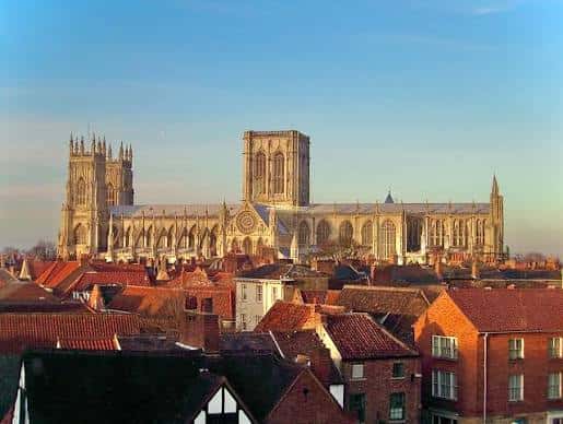 Vista panorámica de la Catedral de York desde una altura, mostrando su fachada gótica y las tejadas rojas de la ciudad