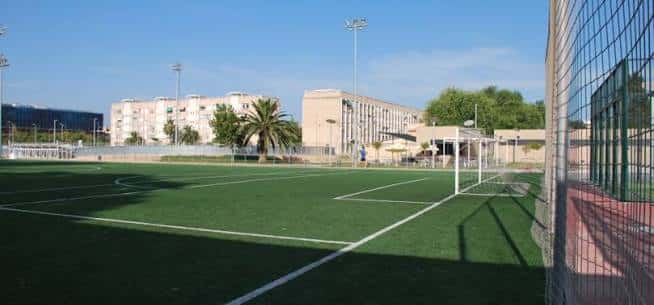 Campo de fútbol con césped artificial verde y portería visible