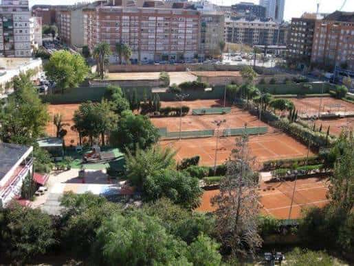 Pistas de tierra batida rodeadas de vegetación en el Sporting Club de Tenis Valencia