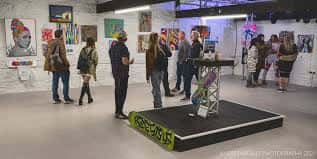 Exposición de arte en el interior de Leadworks con visitantes y obras en las paredes