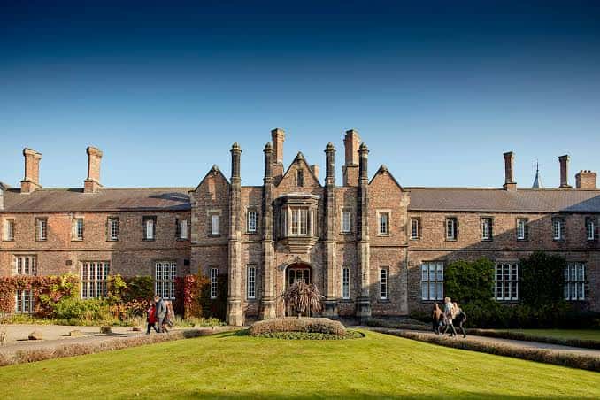 Fachada histórica de un edificio de la Universidad de York con jardines bien cuidados