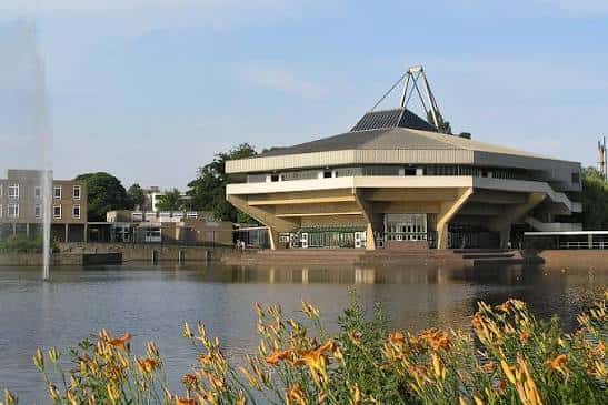 Vista panorámica del Central Hall desde el lago con fuente y flores en primer plano