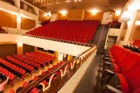 Interior del auditorio con butacas rojas y balcones iluminados