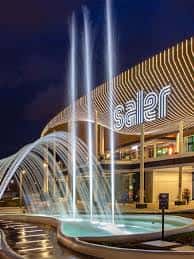 Fachada nocturna del Centro Comercial Saler con fuente iluminada y logotipo visible