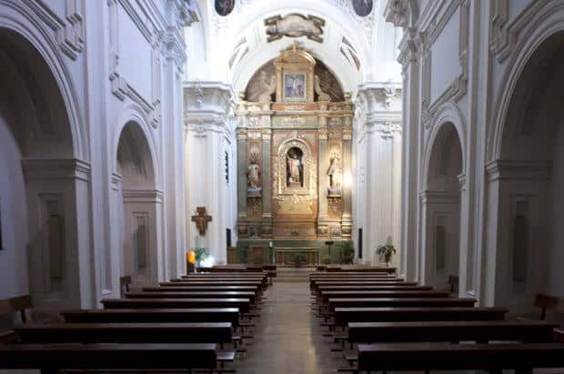 Interior de la iglesia con nave central y retablo dorado