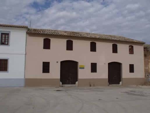 Vista exterior de la Alquería Coca restaurada con fachada clara y puertas de madera