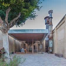 Área exterior del centro con estructura moderna y chimenea industrial, ideal para eventos al aire libre