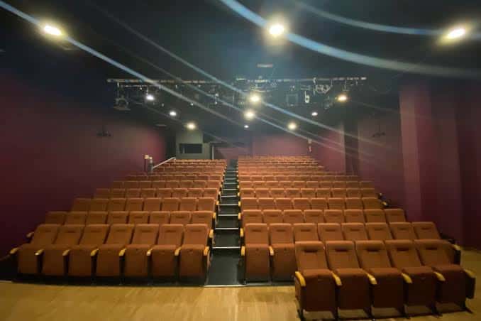 Vista general del auditorio con butacas naranjas y sistema de iluminación profesional