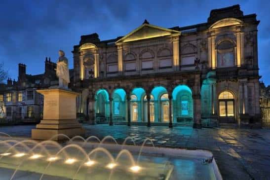 Fachada iluminada de la York Art Gallery por la noche con fuente en primer plano