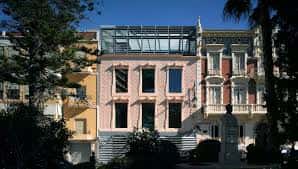 Vista exterior del Palacio Aguirre, sede del MURAM, con su fachada rosa y estructura moderna en la parte superior