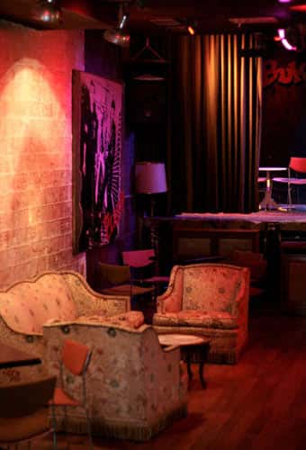 Zona de estar en Le Bukowski con sofás vintage y luz cálida
