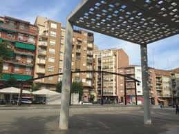 Vista general de la Plaça del Clot de les Granotes con estructura metálica y edificios residenciales al fondo