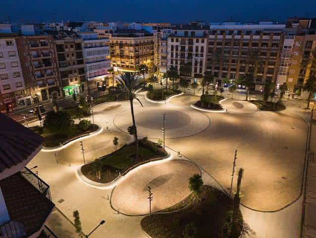 Vista nocturna de la Plaza de La Merced con iluminación ambiental y diseño curvilíneo