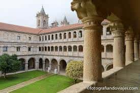 Claustro del monasterio con columnas románicas y patio ajardinado