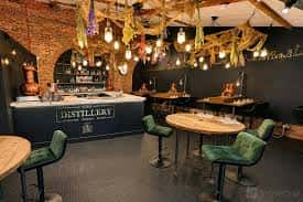 Interior del bar de la destilería con decoración rústica y luces colgantes