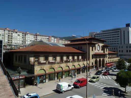 Vista exterior de la Estación del Norte en Oviedo con su fachada de arcos y tejado de tejas bajo un cielo azul