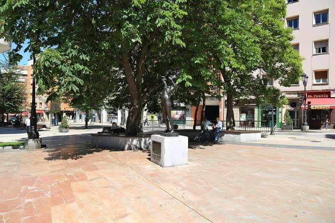 Plaza con la escultura «Vida» y árboles en Oviedo