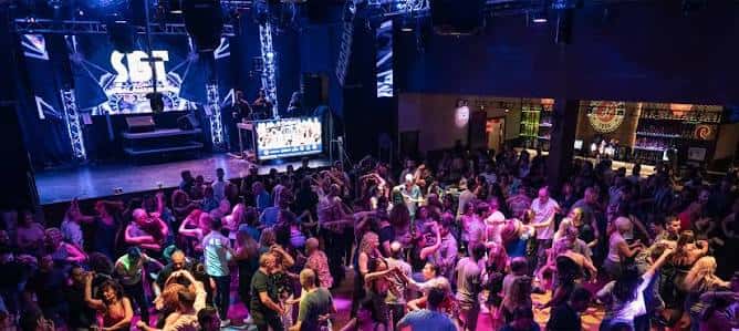 Vista panorámica del interior de la sala Salamandra durante una sesión de baile con público y escenario iluminado
