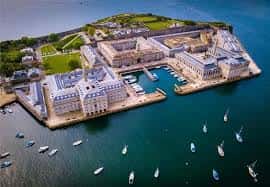 Vista aérea del Royal William Yard con edificios históricos y embarcaciones en el puerto