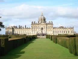 Vista frontal del Castillo de Howard con jardines formales y césped verde