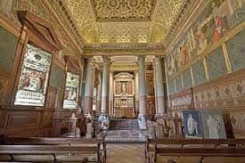 Interior del salón principal con techos dorados, columnas y murales históricos