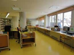 Interior de la biblioteca con zona de lectura y escritorios junto a ventanales