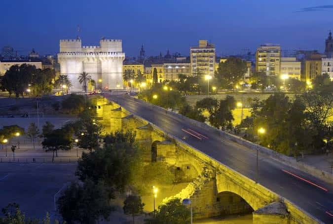 Vista nocturna del Puente de Serranos con la Torre de Serranos iluminada al fondo