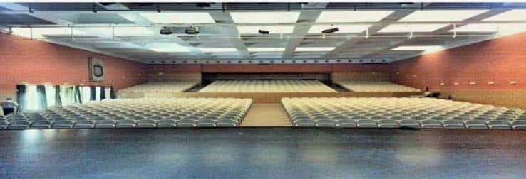 Vista panorámica del auditorio desde el escenario, mostrando la distribución de asientos y techo con paneles luminosos