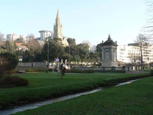 Área de los Jardines Centrales con monumento histórico y vista de la catedral en el fondo