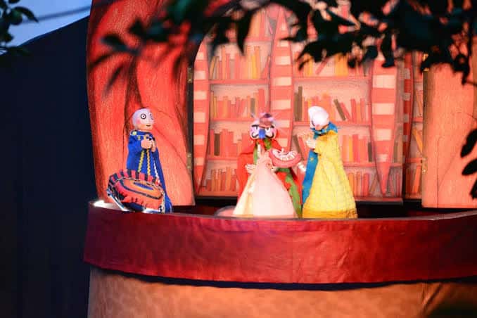 Escenario con títeres iluminados en ambiente teatral