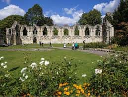 Vista panorámica de las ruinas de la abadía de York con jardines floridos al frente