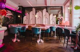 Interior del bar con decoración art deco y luces de neón rosa