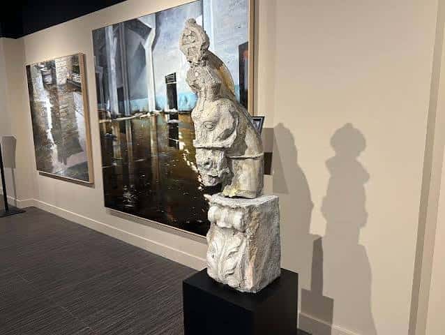 Detalle de una escultura de piedra sobre pedestal en la sala