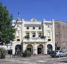 Vista exterior del cine en Preston Circus, Brighton, con bicicletas y peatones en primer plano
