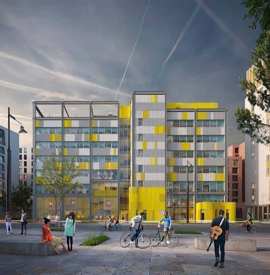 Vista arquitectónica del edificio Plus X Innovation con su distintiva fachada amarilla y gris