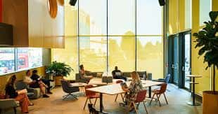 Espacio interior de coworking con grandes ventanales y zona de descanso
