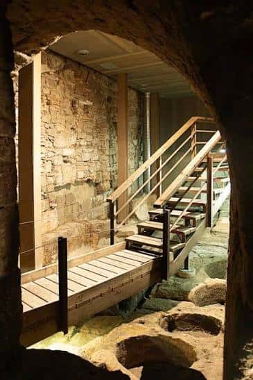 Vista interior de las antiguas curtidurías con escaleras de madera y muros de piedra